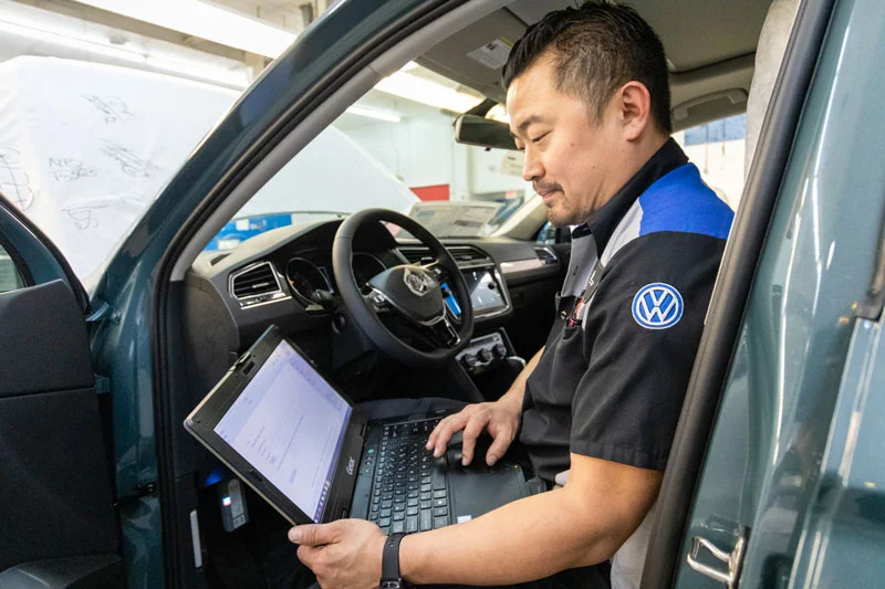 A Volkswagen Certified Technician running diagnostics on a vehicle