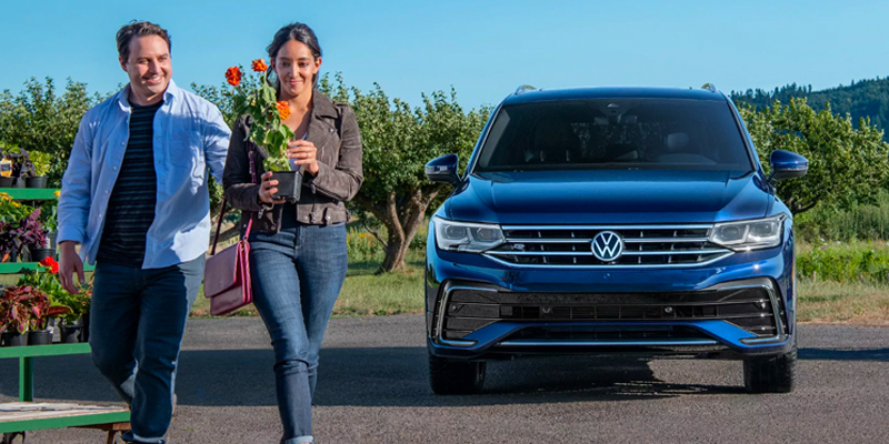 A couple arriving at a party in their Volkswagen SUV
